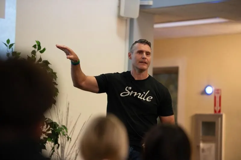 Steve Grandizio speaking to an audience with one hand raised